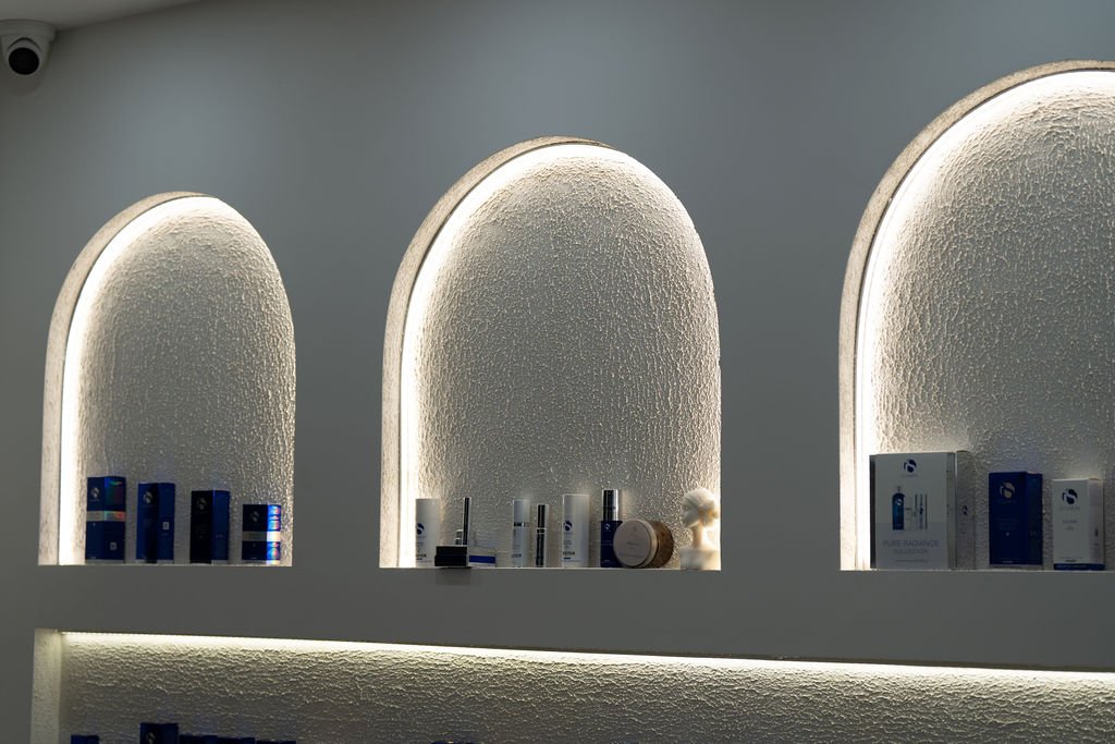 iS Clinical skincare products displayed in backlit arched alcoves at Eternity clinic